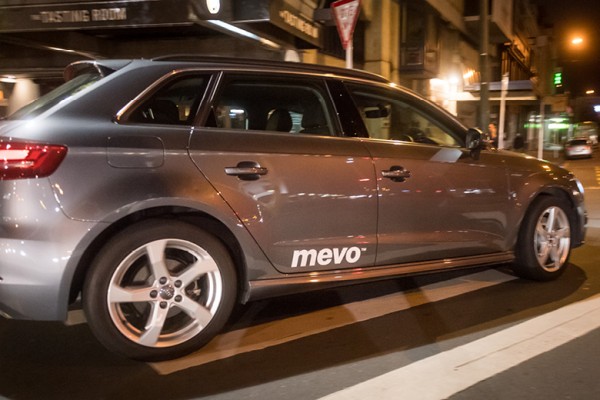 Image shows a Mevo car driving down a city street
