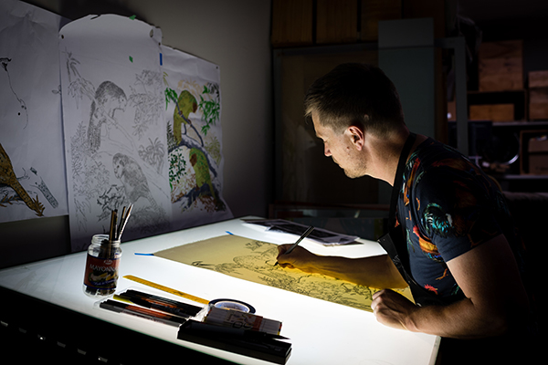 Image shows Ben working on designs at a light table