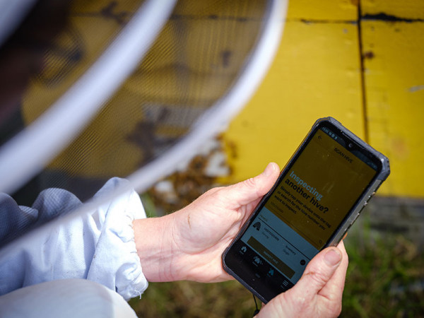 Person holding a smartphone with BuzzTech's app. 